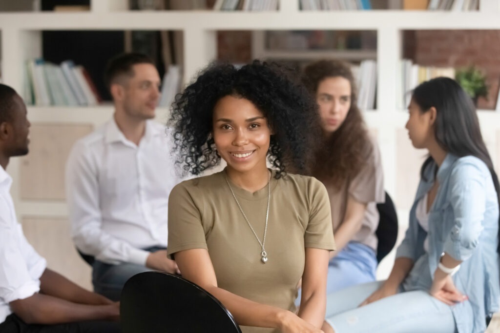 African american female psychologist psychotherapist looking at camera during group therapy session, black woman coach counselor therapist posing during team training with diverse people,